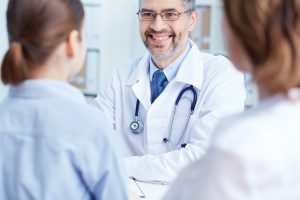 Confident Doctor speaking to patients in hospital